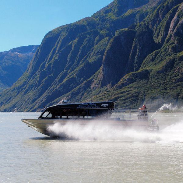a small boat in a body of water with a mountain in the background