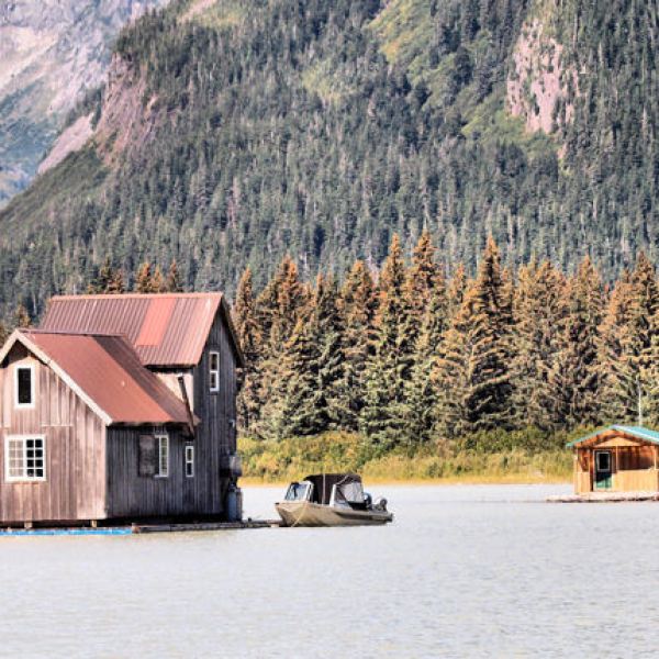 a small house in a body of water with a mountain in the background