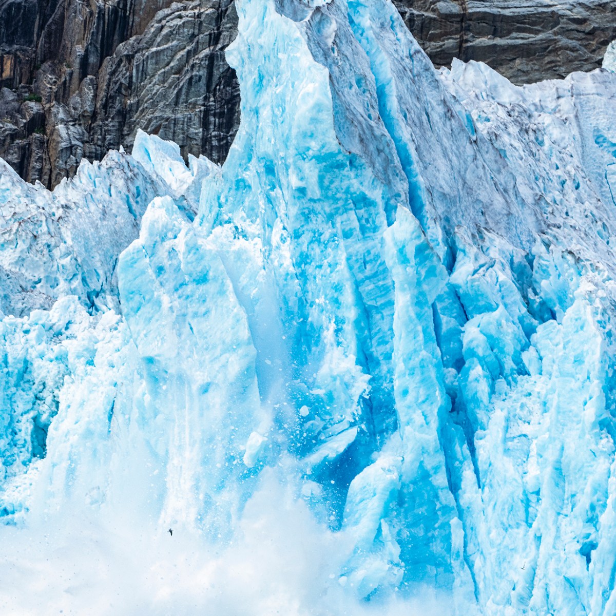 a large waterfall over a snow covered mountain